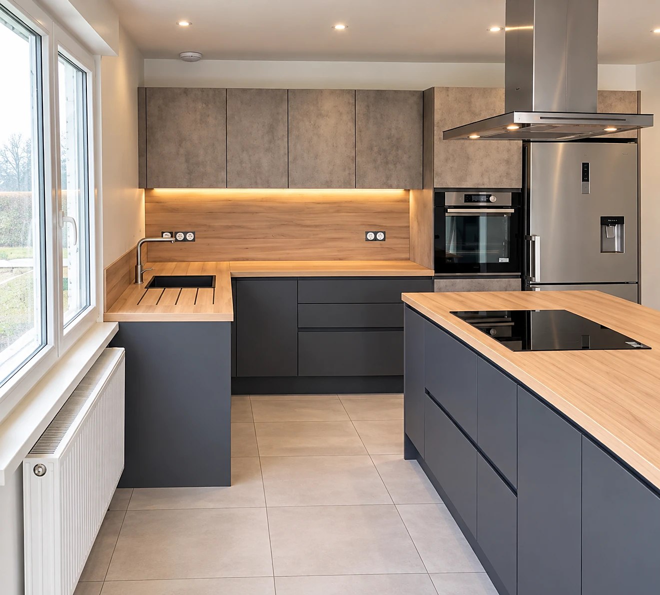 Cuisine anthracite et bois avec îlot central, hotte inox et LED sous meubles